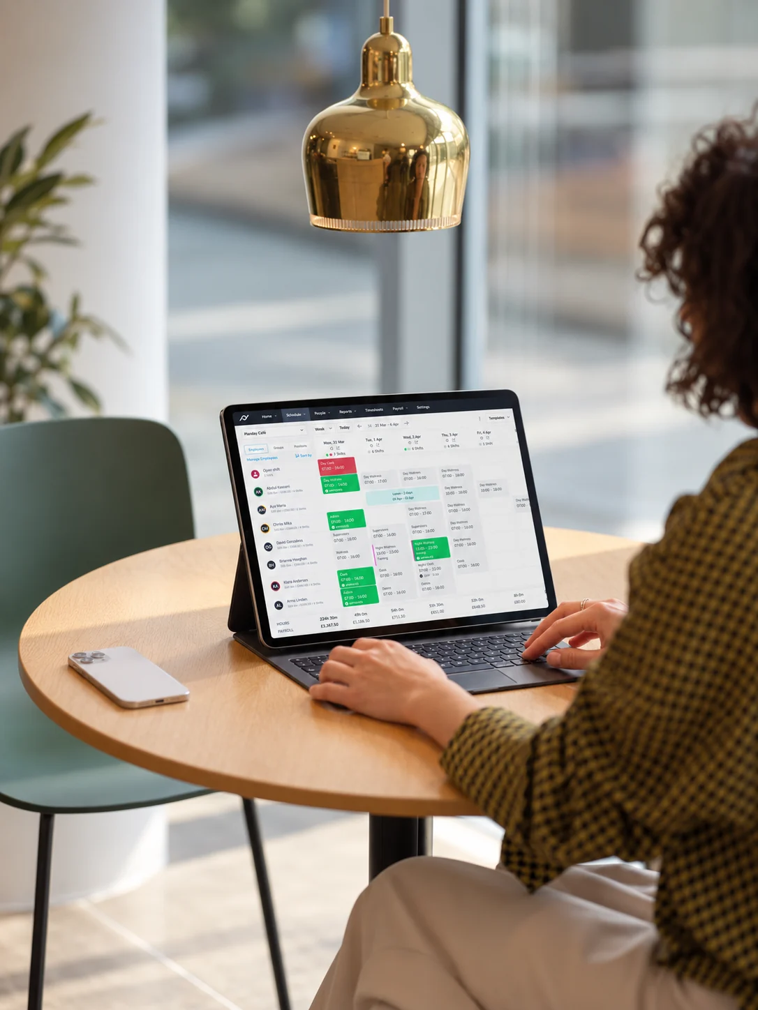 Planday's schedule on a tablet on a café table