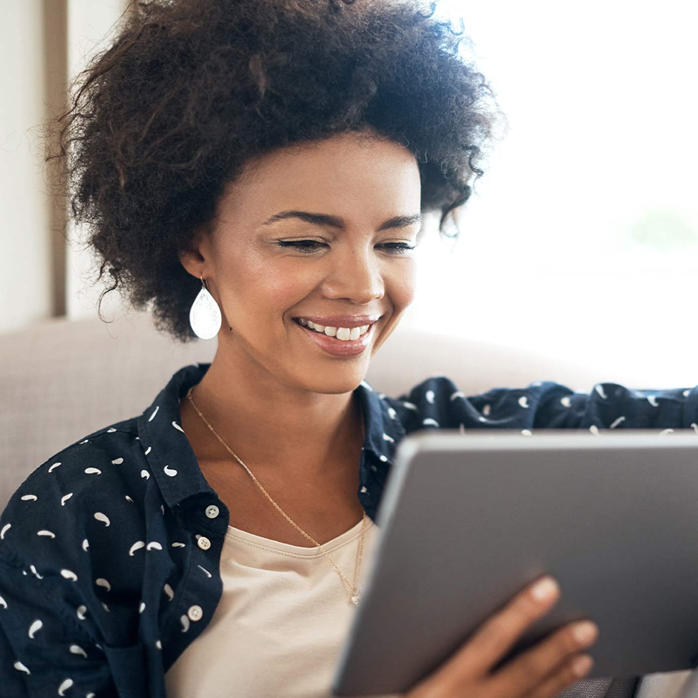 Woman in chair working with Zenegy Numbers on her tablet.