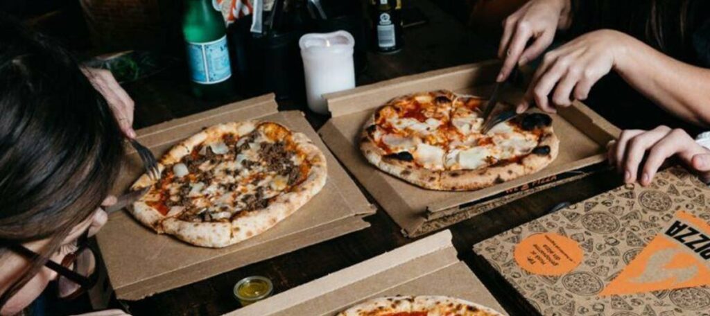 Personer der deler et par pizzaer.