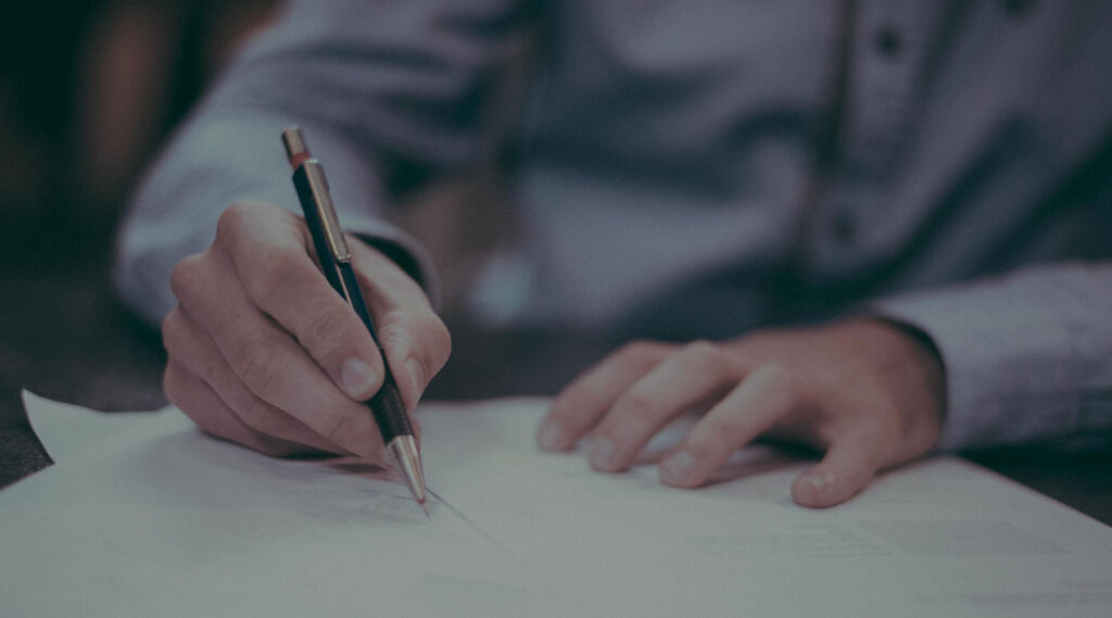 Person der skriver i en notesbog der omhandler regnskab.